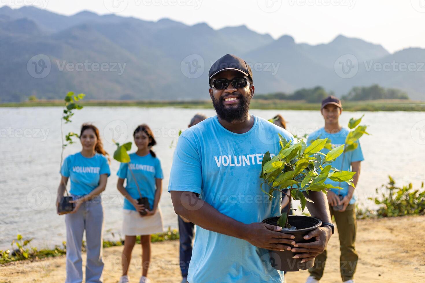 Team of young and diversity volunteer workers group enjoy charitable social work outdoor in tree forest planting NGO work for fighting climate change and global warming coastline habitat project photo