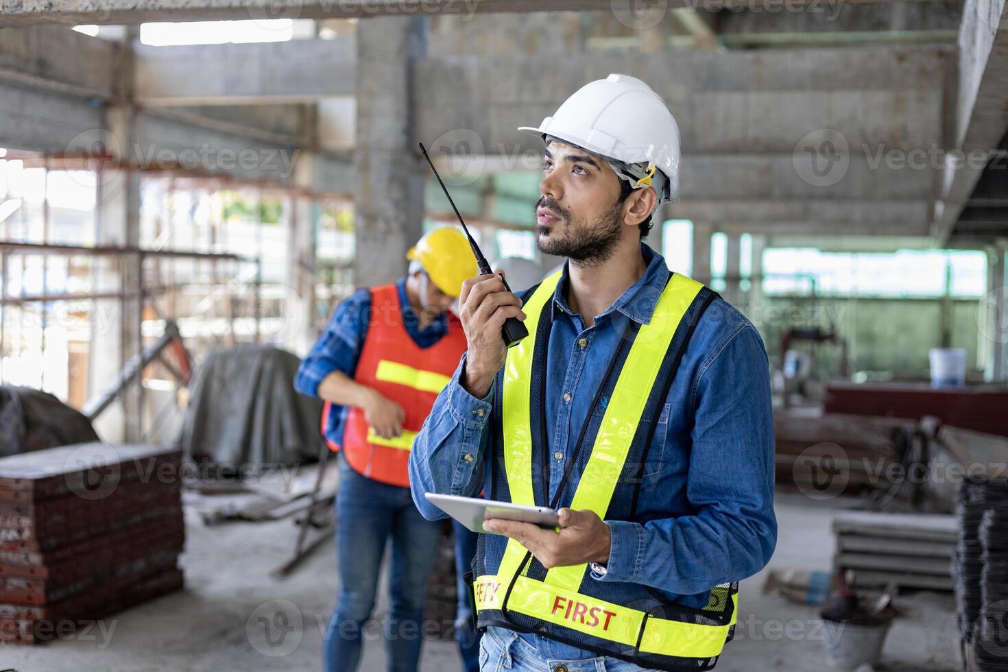 Caucasian engineer with radio walkie talkie in full safety gear is inspecting the crack and leak inside the building structure for investigation over specification and quality control photo