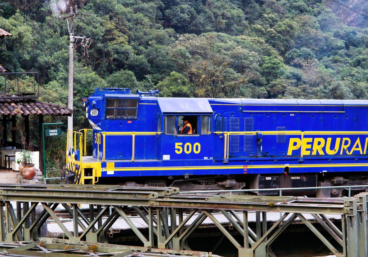 aguas calientes, Perú, 2015 - ferrocarril azul y amarillo motor Moviente mediante pueblo foto