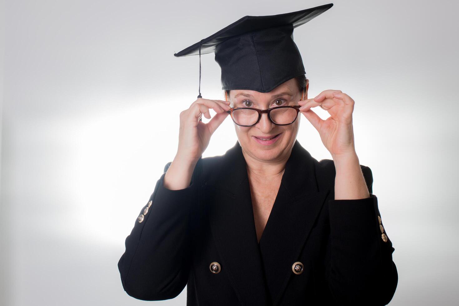 Mature woman with glasses and graduation cap photo