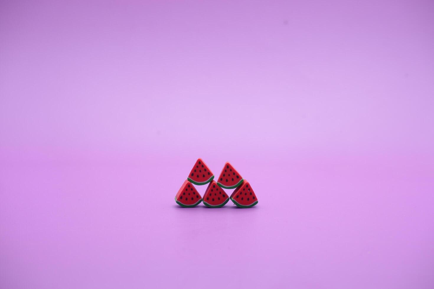 Mini watermelon toy isolated on purple background. purple background with watermelon toys. photo