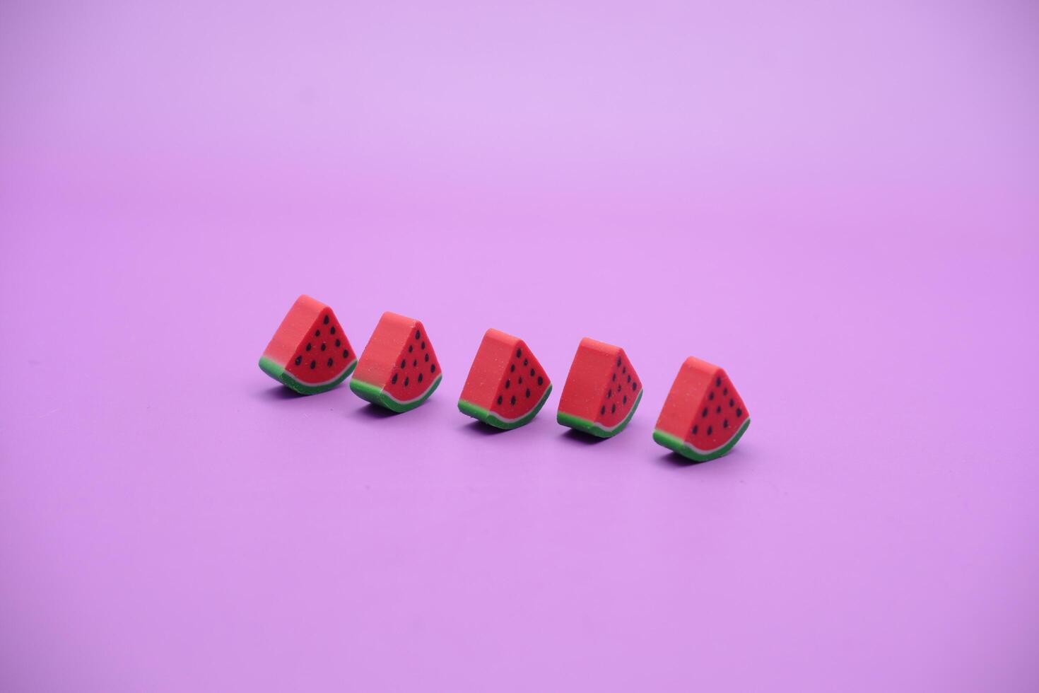Mini watermelon toy isolated on purple background. purple background with watermelon toys. photo