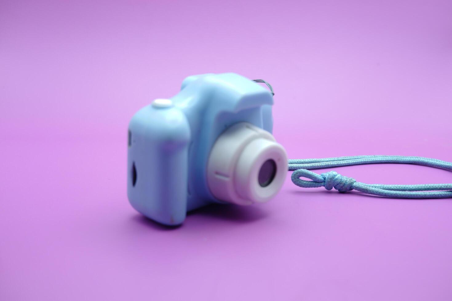 toy camera isolated on purple background. blue children's toy camera. photo