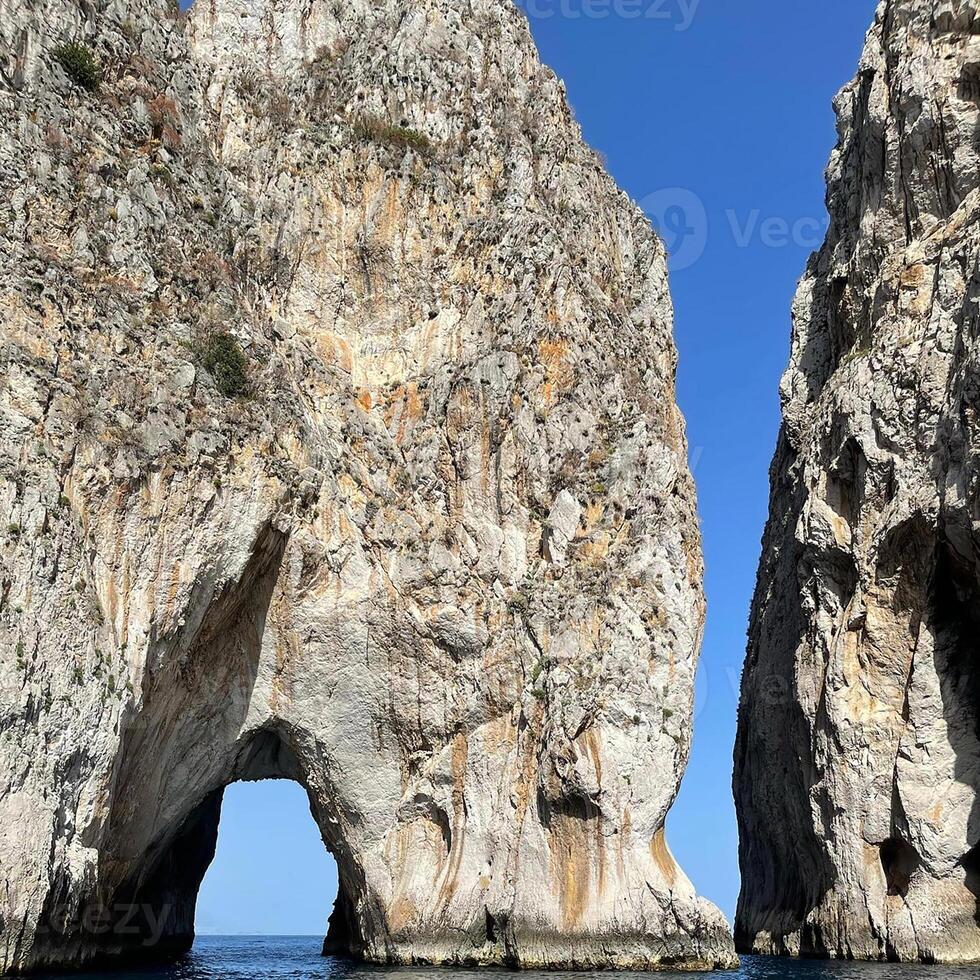 two large rock formations in the ocean photo