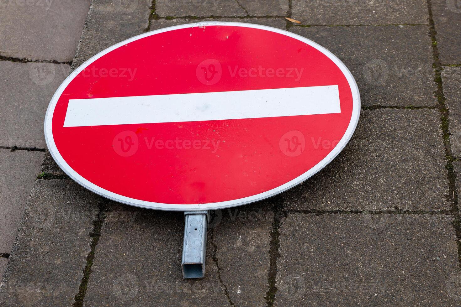 a road sign lying on the sidewalk no entry photo