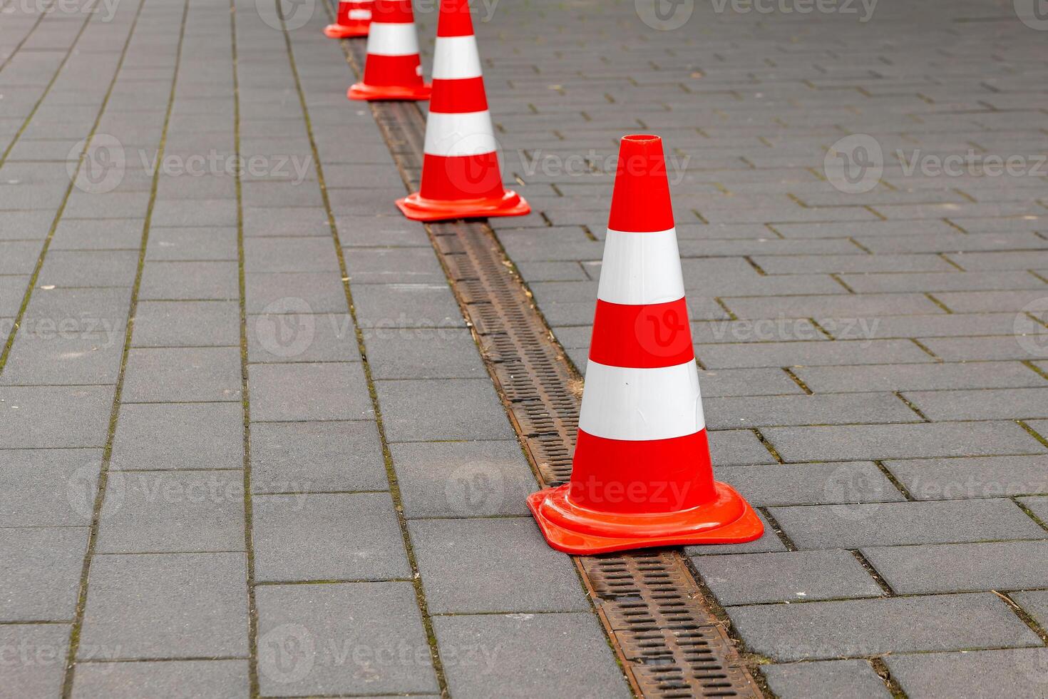 red and white road cones on a footpath photo