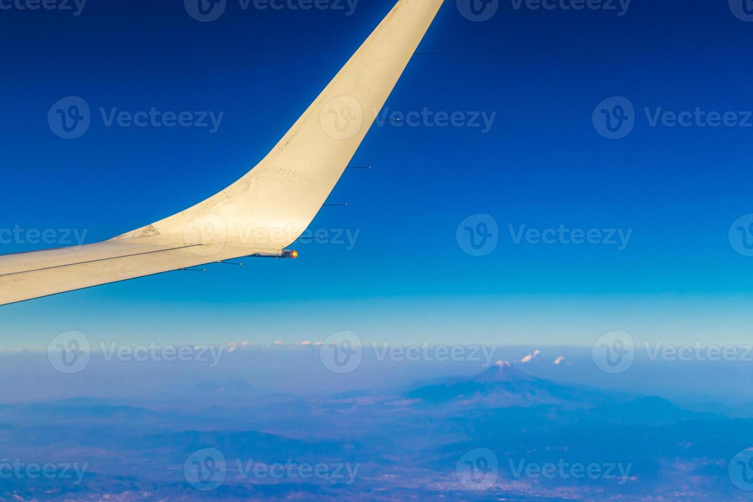 Flying airplane over Mexico Clouds Sky Volcanoes Mountains City desert. photo