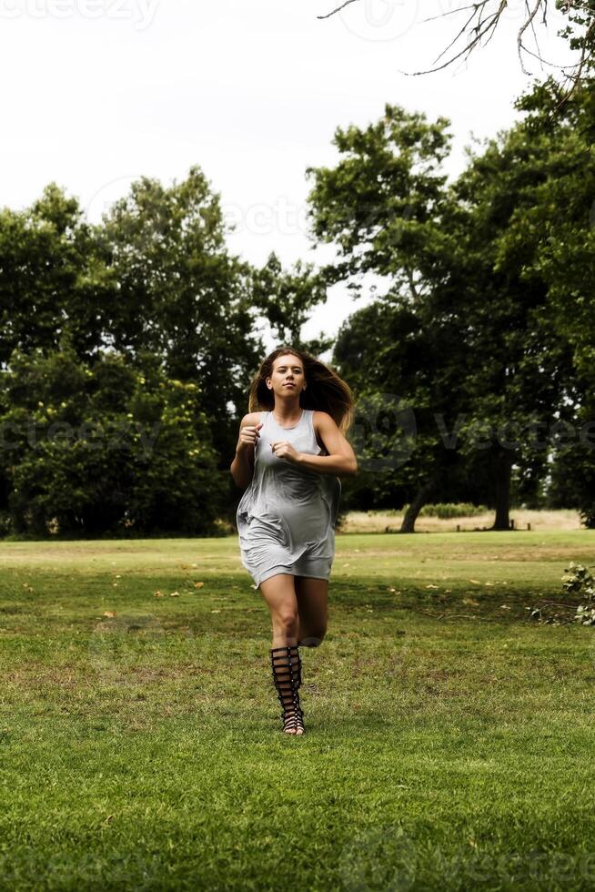 Caucasian Teen Woman Running In Park Gray Dress photo