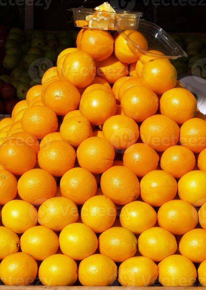 Pyramid of oranges in store front display photo