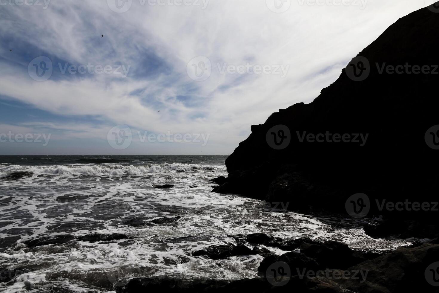 Ocean Waves Blue Sky White Clouds And Silhouetted Shore photo