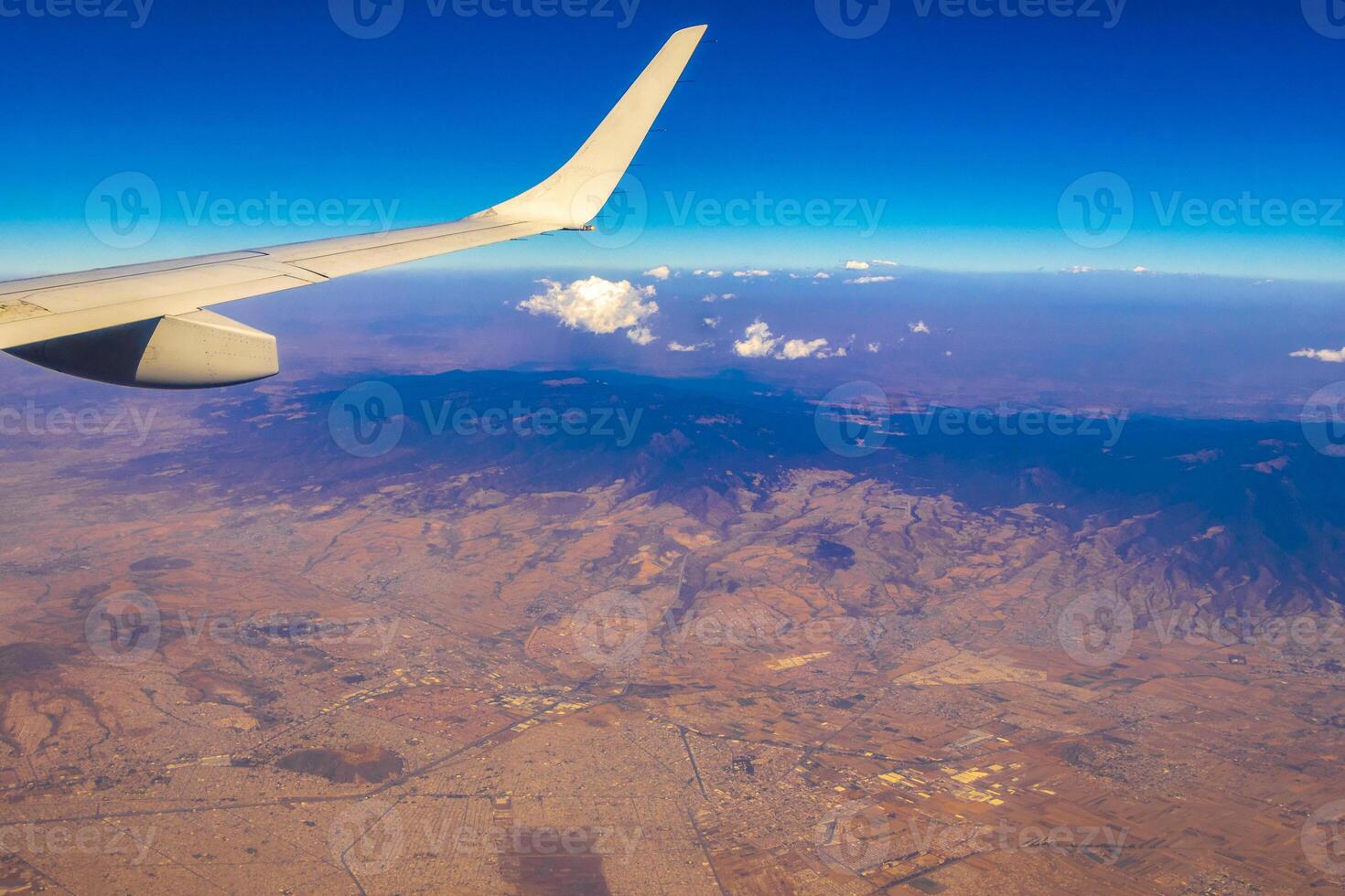 Flying airplane over Mexico Clouds Sky Volcanoes Mountains City desert. photo