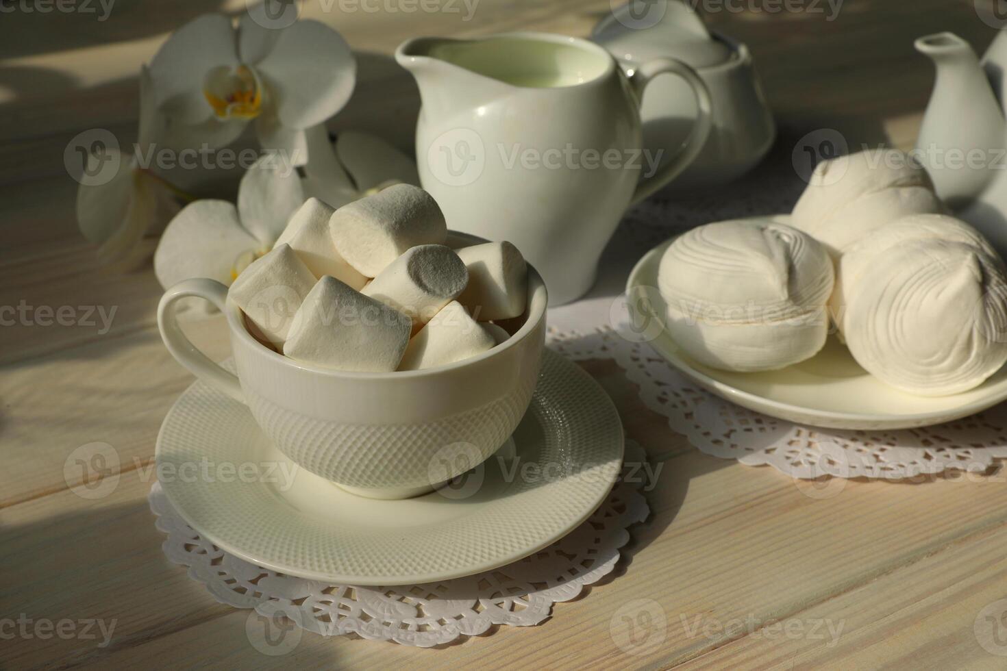 primavera desayuno con malvavisco, café y leche. flatlay con comida y flor en blanco color foto