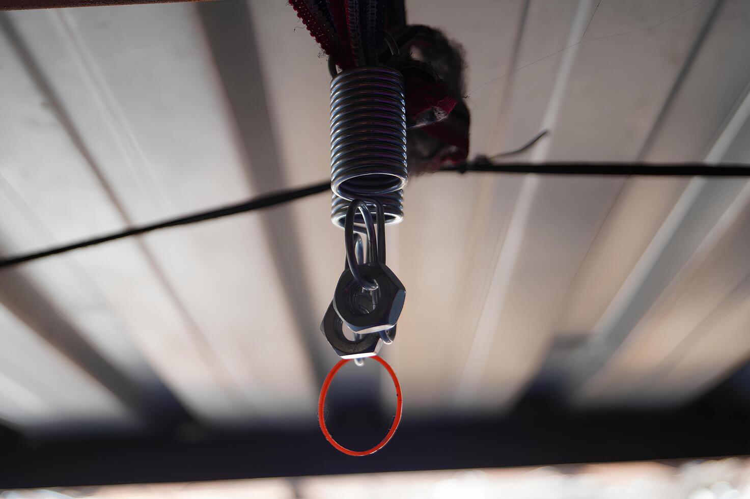 Metal Spring and Clip Attached to a Wire Indoors photo