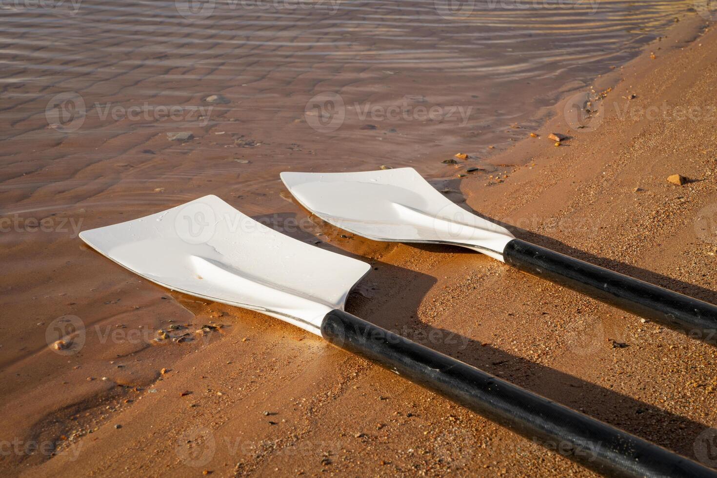 blades of hatchet sculling oars against grunge, rustic wooden deck photo