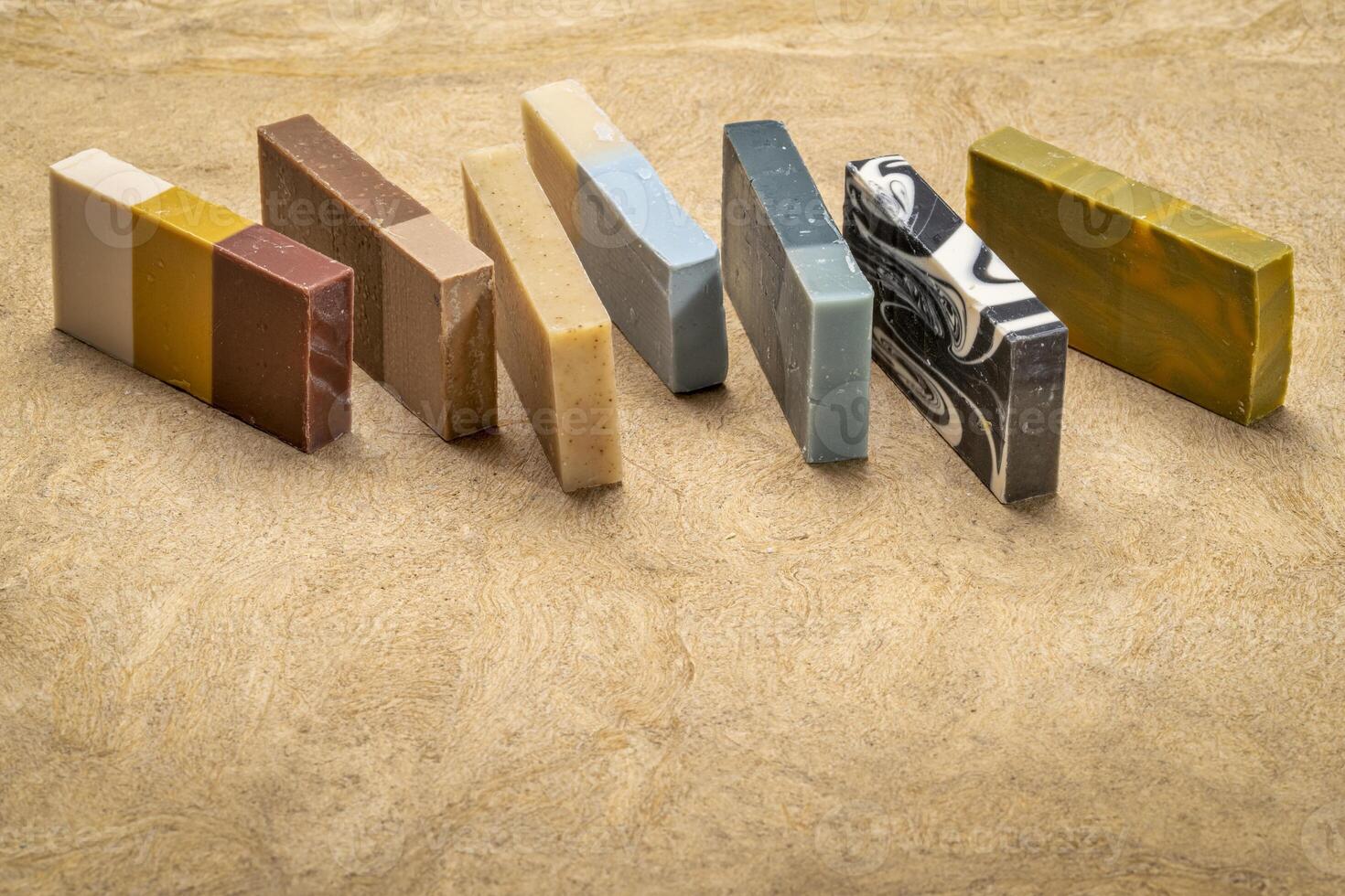 variety of 7 organic, artisan soap bars on a textured bark paper photo