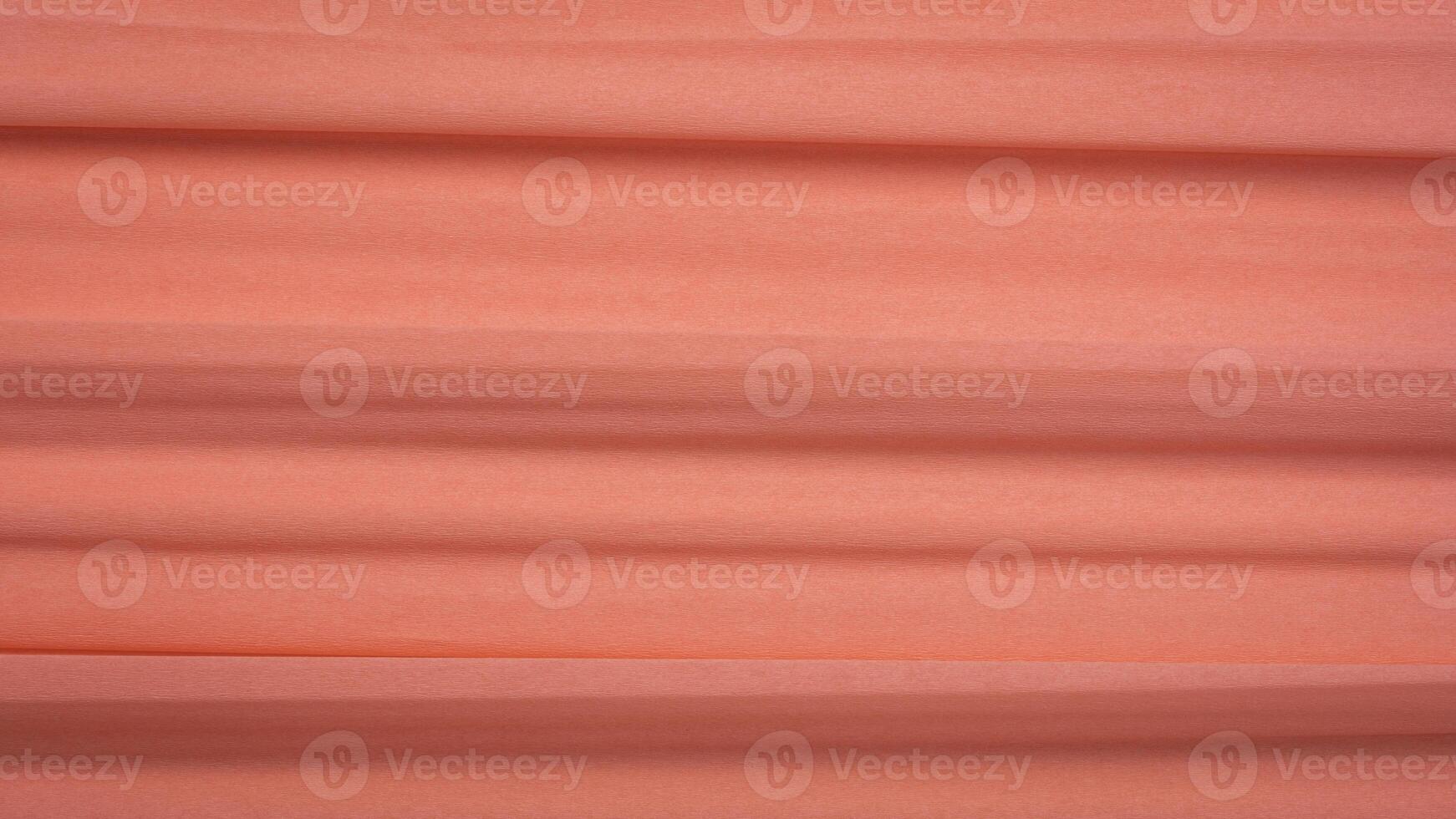 salmon color crepe paper - background with crinkled texture photo