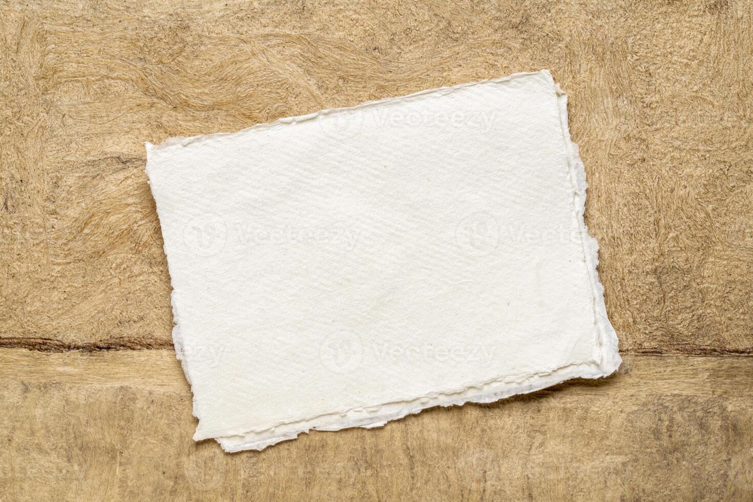 sheet of blank white Khadi rag paper against abstract landscape in earth tones photo