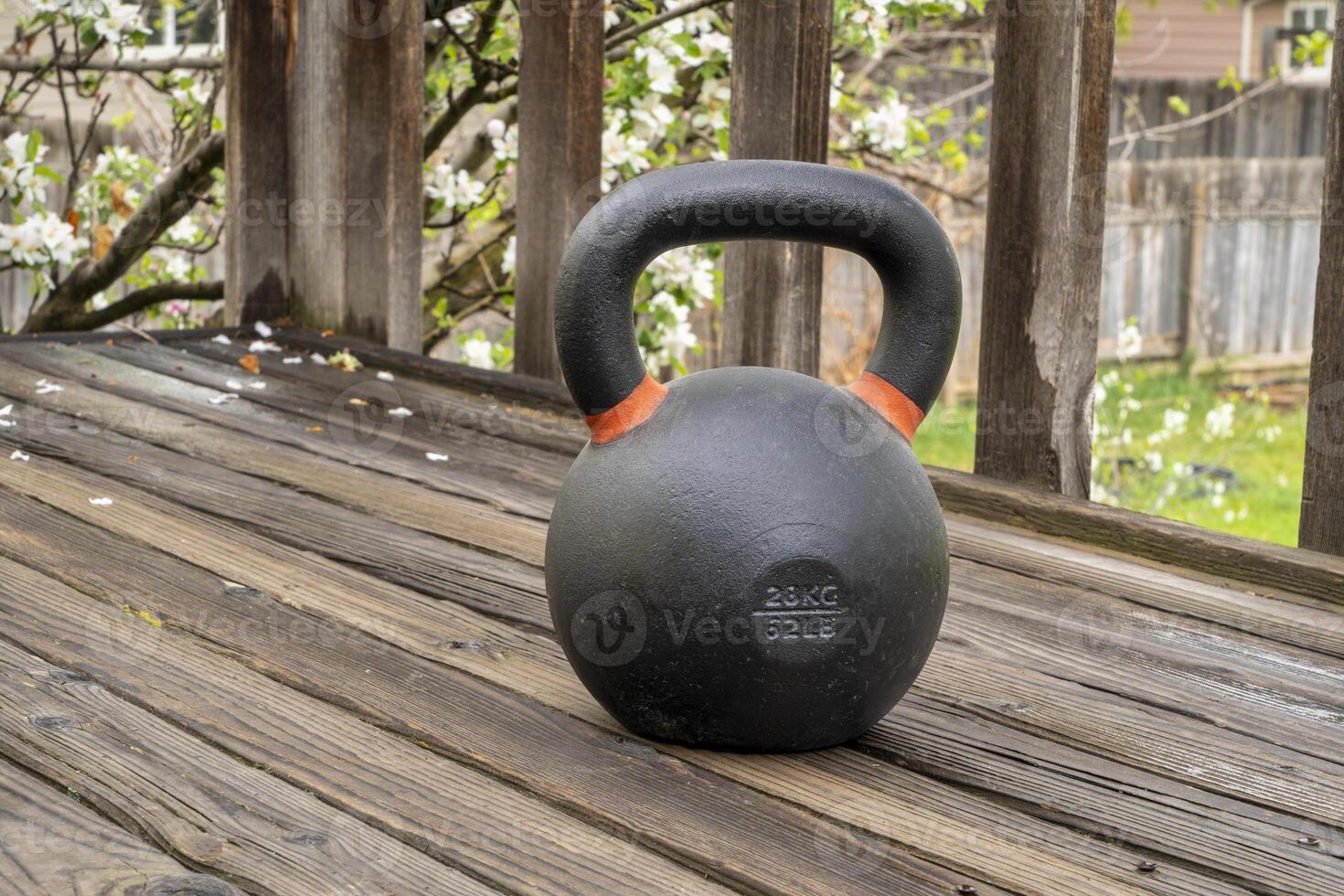 heavy iron competition kettlebell for weight training on wooden grunge deck, home gym and fitness concept photo