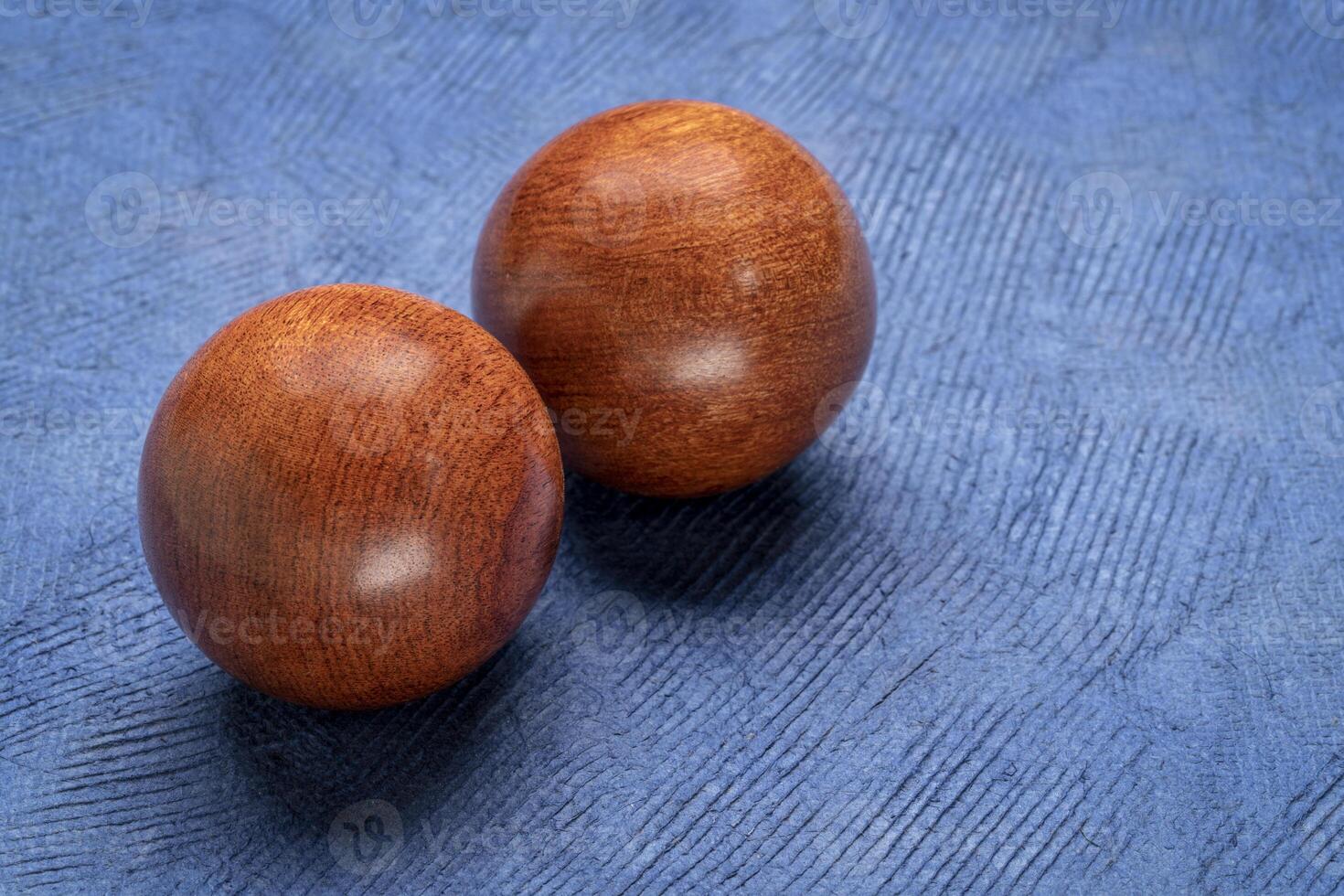 a pair of wooden Chinese medicine balls on textured paper photo