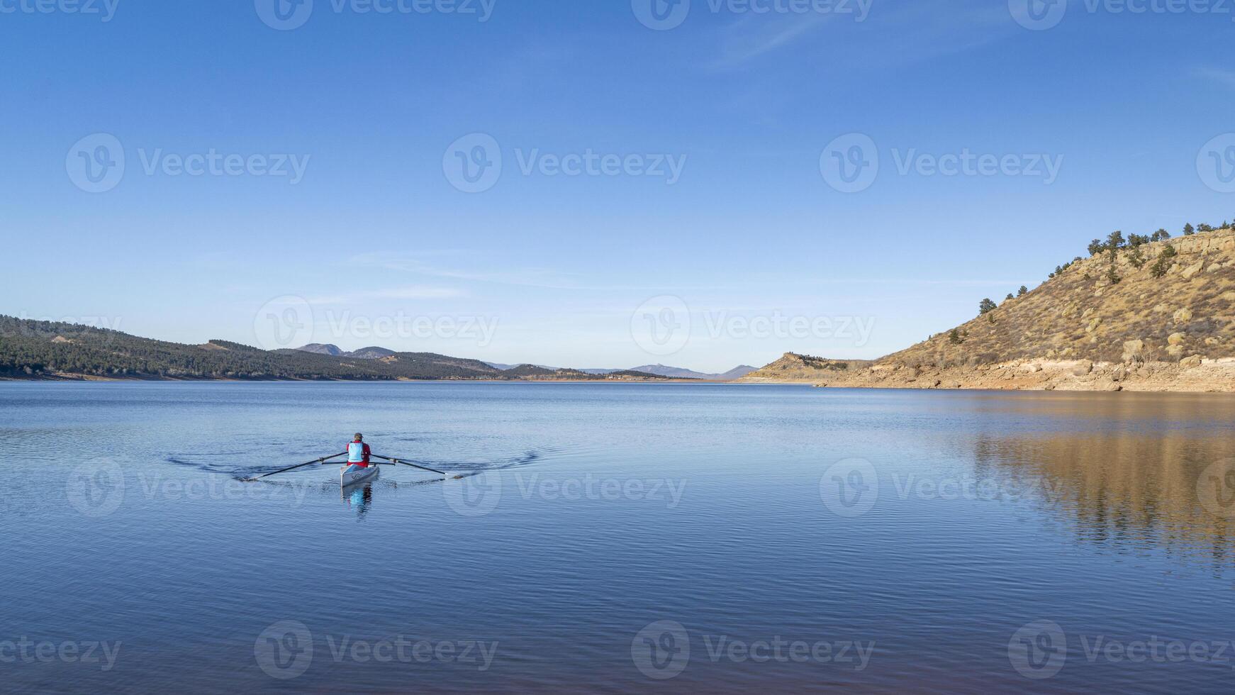 Lonely rower in a coastal rowing shell - Carter Lake in fall or winter scenery in northern Colorado. photo