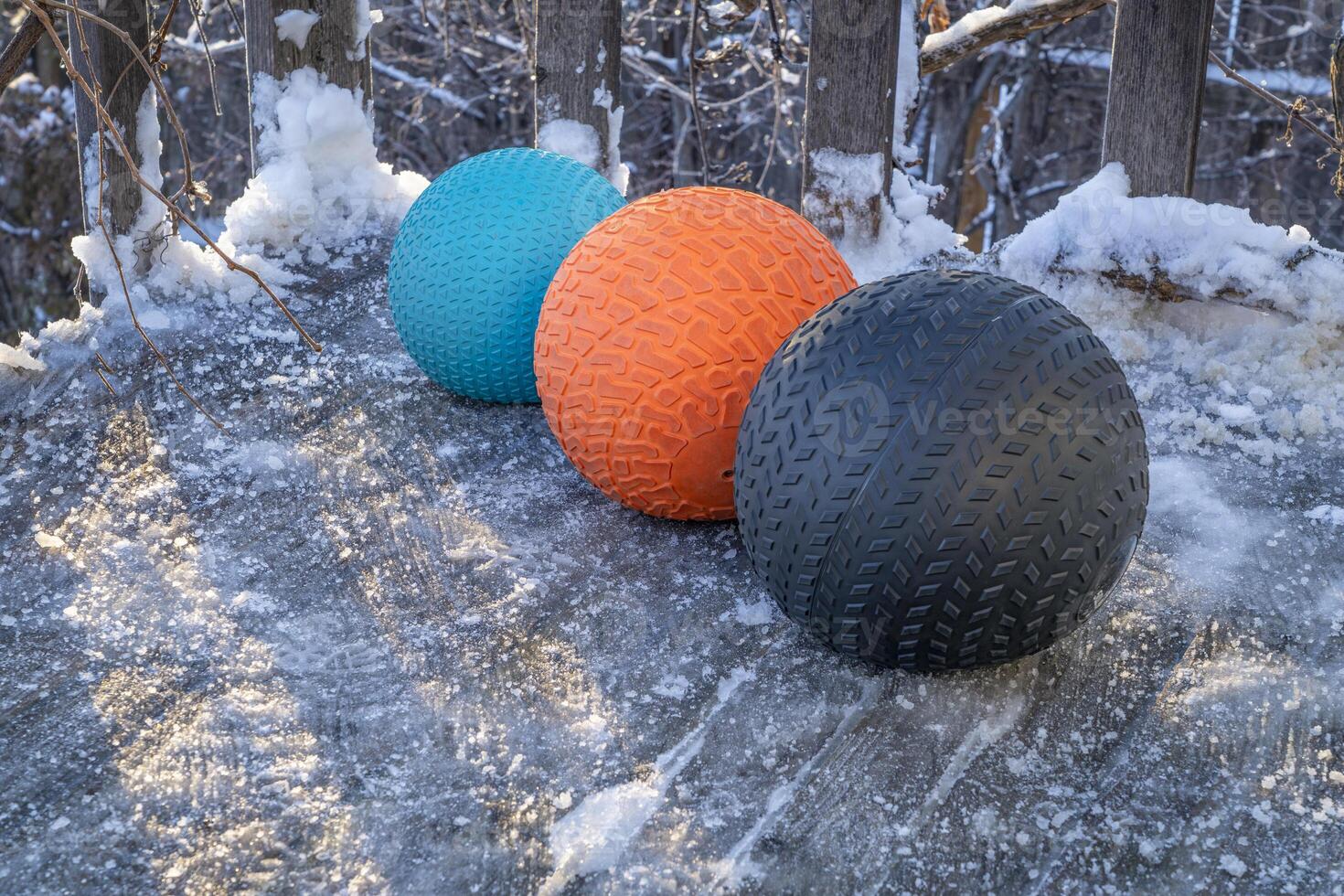 heavy slam balls filled with sand on an icy backyard deck, exercise and functional fitness concept photo