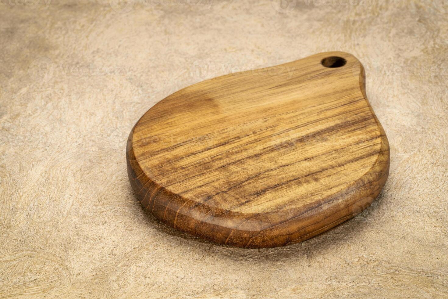 mini wooden cutting board with a handle on textured bark paper photo