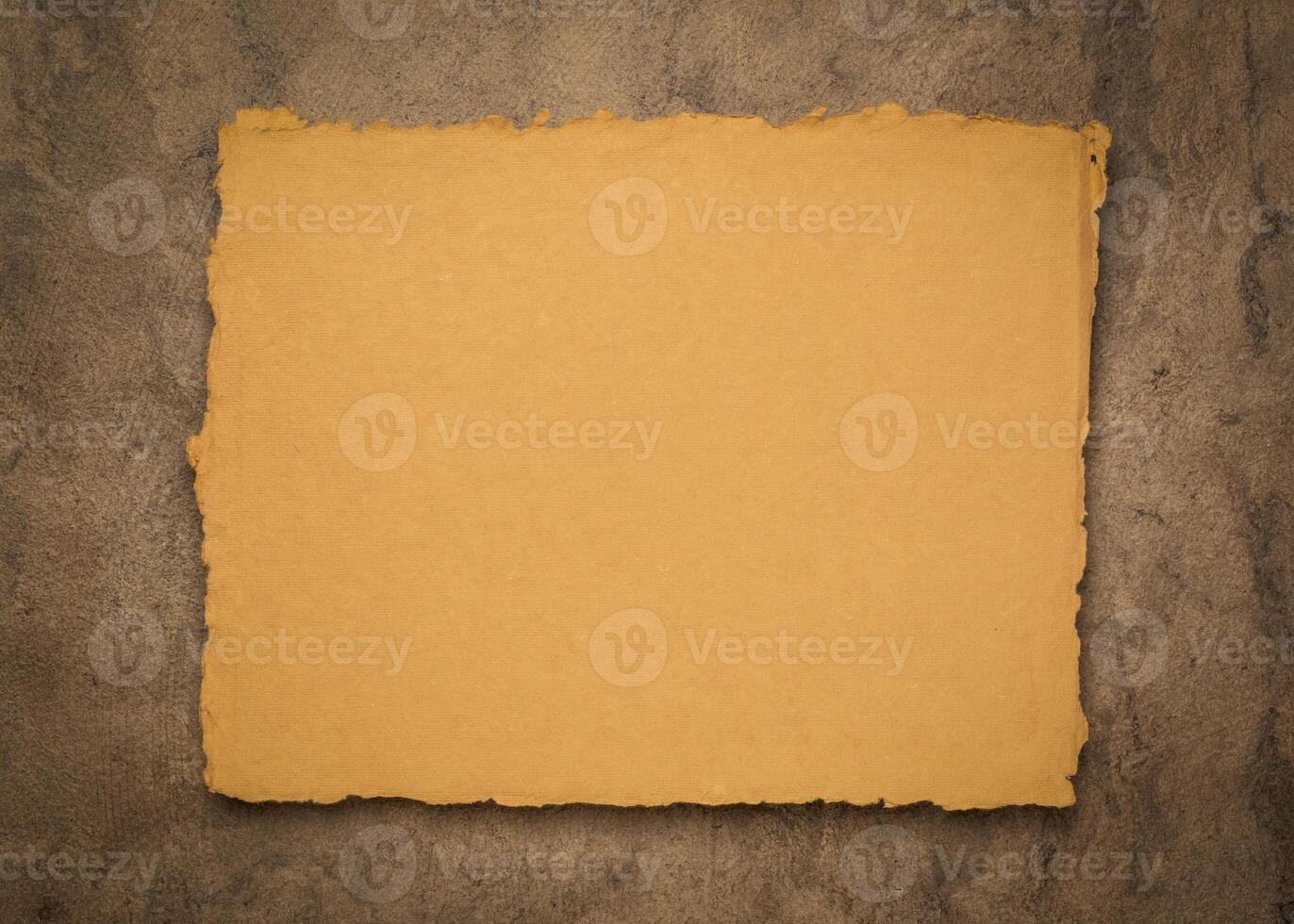 sheet of blank Indian handmade rag paper against textured bark paper, copy space photo