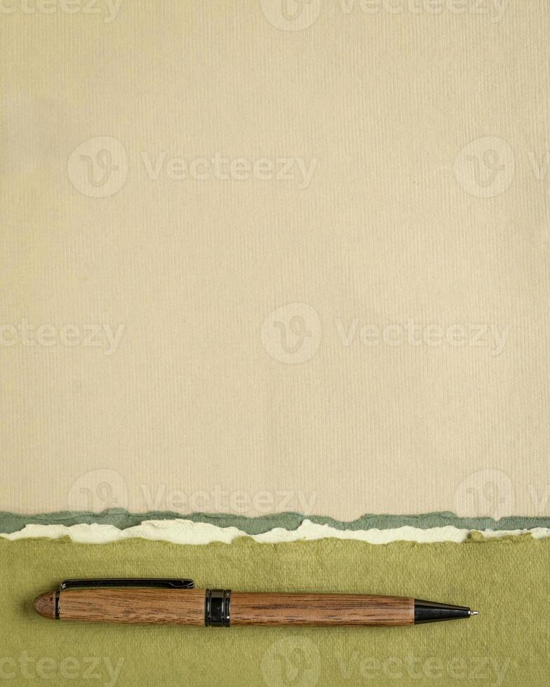 abstract paper landscape in pastel earth tones tones - collection of handmade rag papers with a wooden pen photo