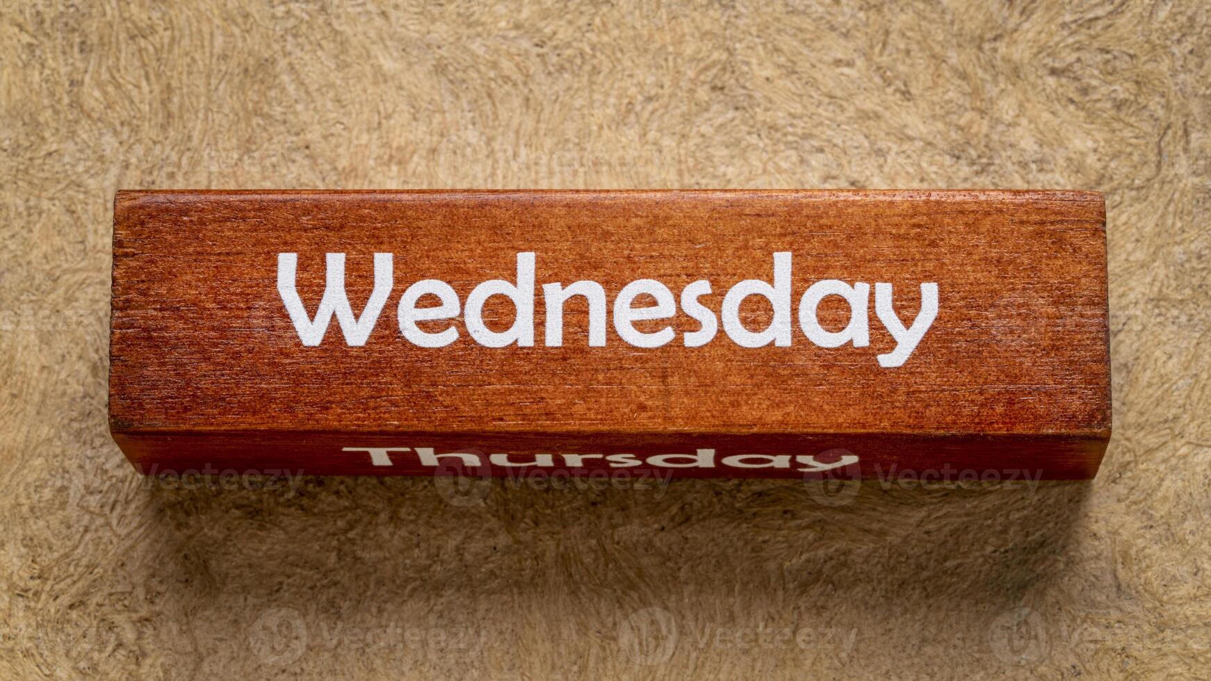 Wednesday and Thursday text on wooden block against handmade bark paper in earth tones, calendar concept photo