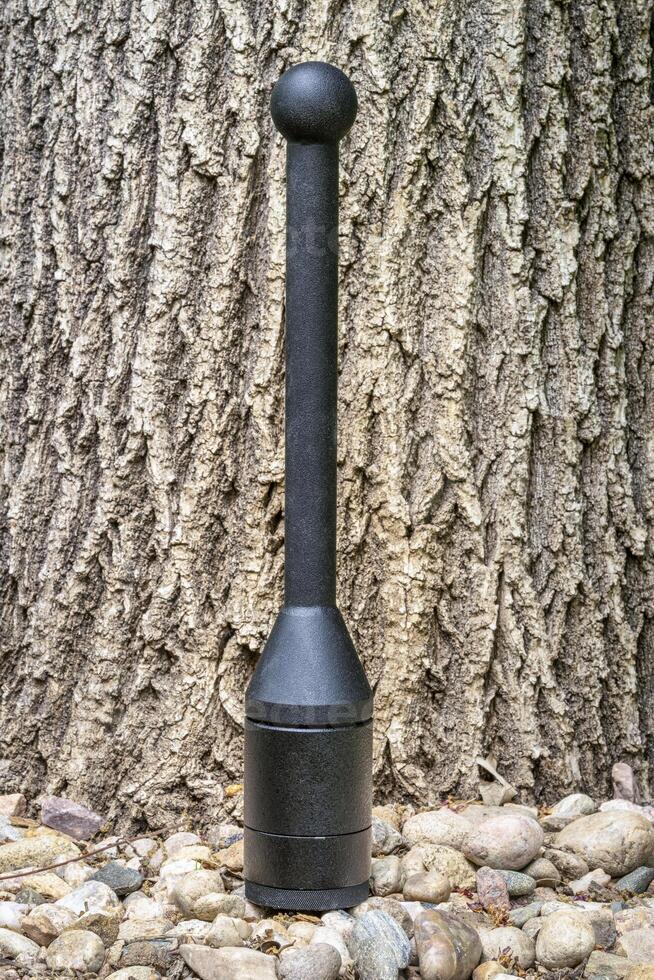 adjustable weight steel club in backyard, functional fitness concept, heavy clubs are particularly valuable for grip strength, shoulder work, and rotational core power photo