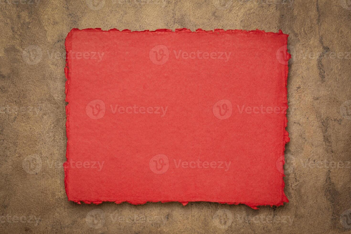 red and brown abstract - a sheet of blank Indian handmade rag paper against textured bark paper, copy space photo