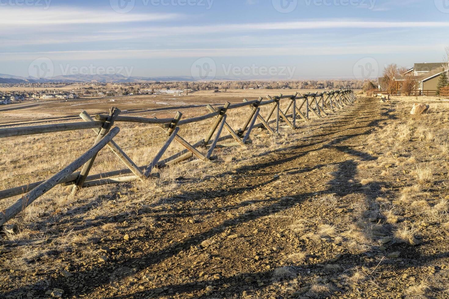 wooden fence and dirt biking trail along a residential area at Colorado foothills photo