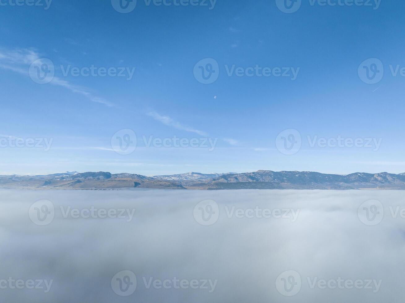 dense fog covering foothills of northern Colorado with clear mountains at a horizon, aerial view of winter morning photo