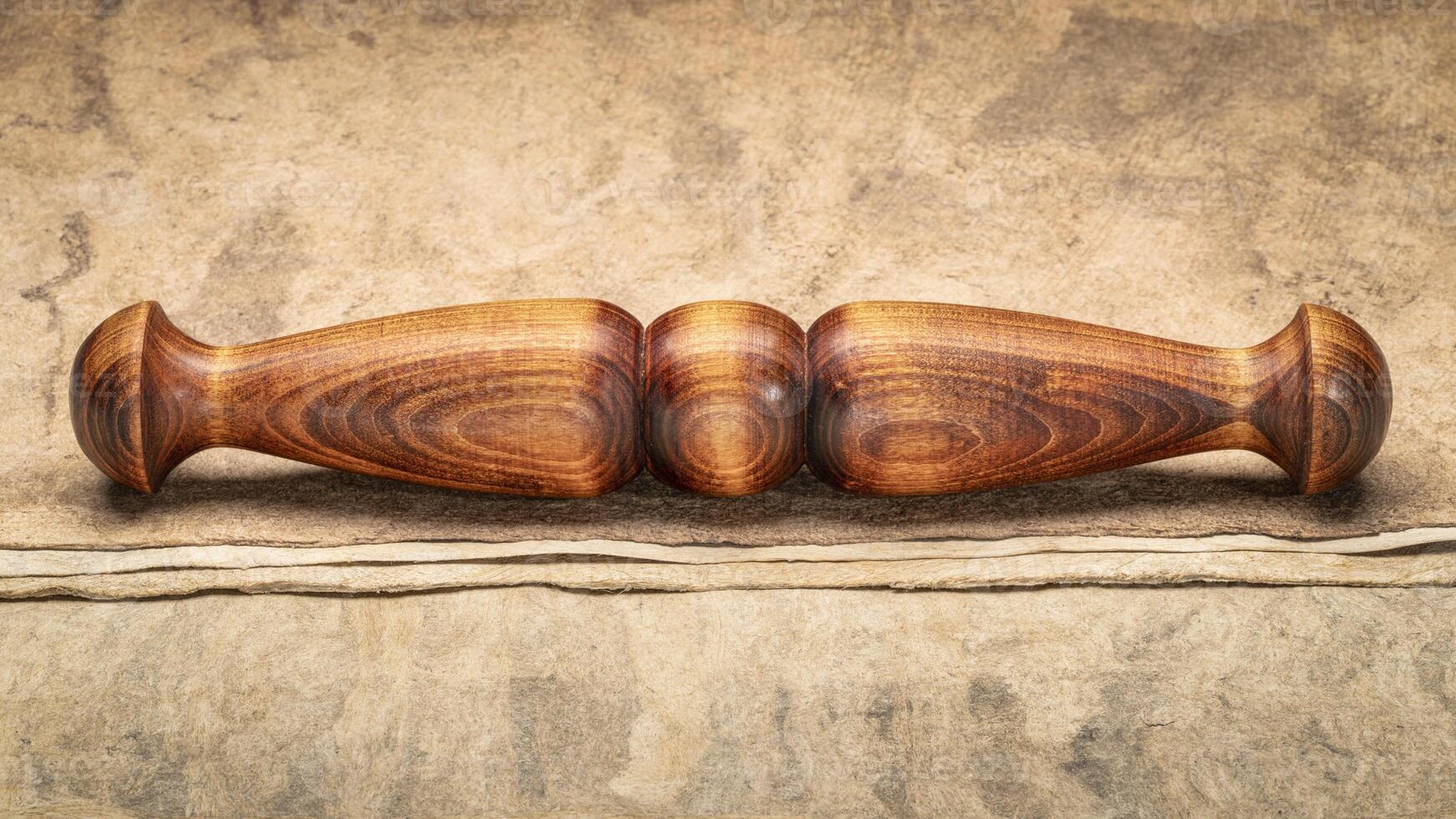 Wooden Tai Chi ruler, a  traditional Chinese exercise tool, on textured bark paper photo