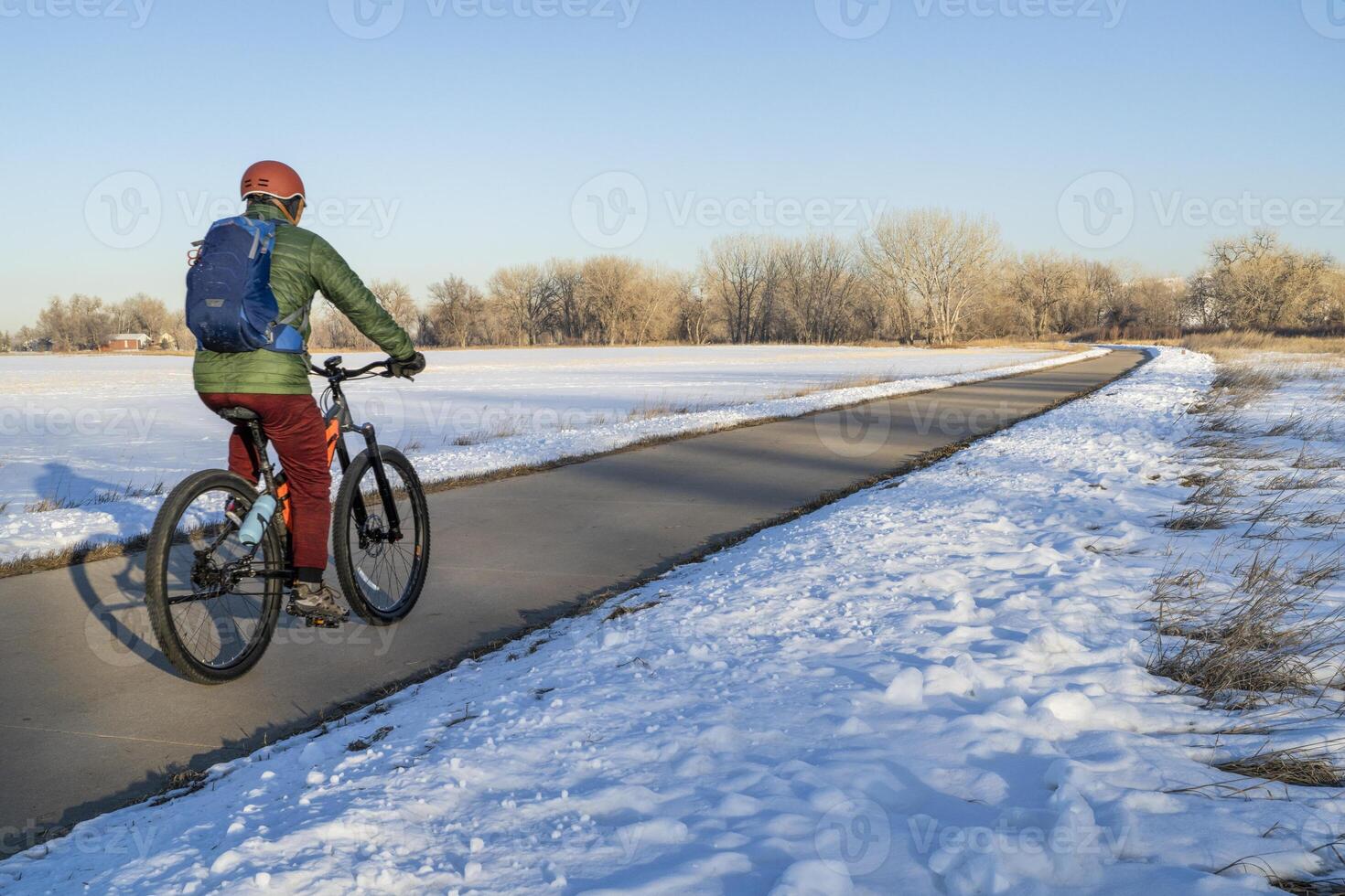 masculino ciclista en un bicicleta sendero en invierno paisaje - poudre río sendero en del Norte Colorado, andar en bicicleta, recreación y desplazamientos concepto foto
