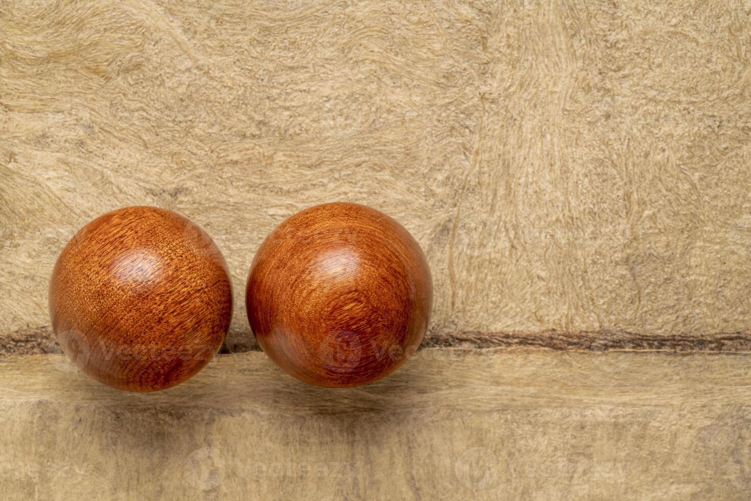 a pair of wooden Chinese medicine balls on textured paper photo