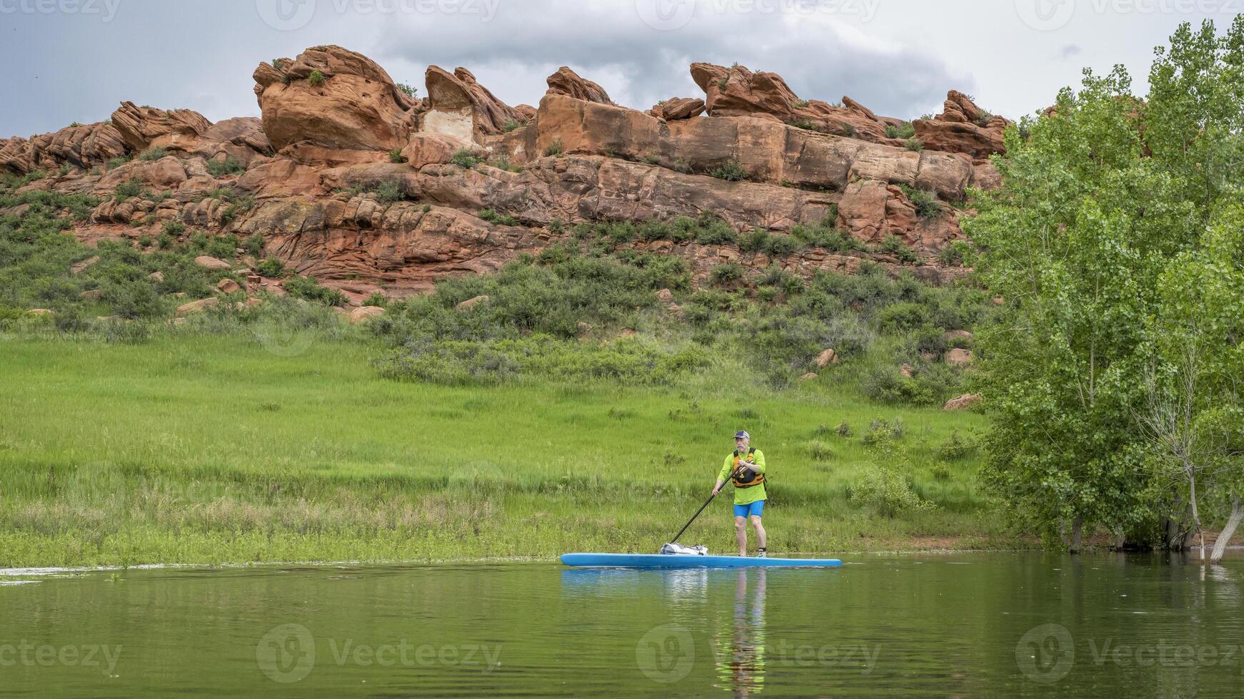 mayor masculino palista en un turismo estar arriba paddleboard en lago en Colorado estribaciones - diente de caballo reservorio cerca fuerte Collins foto