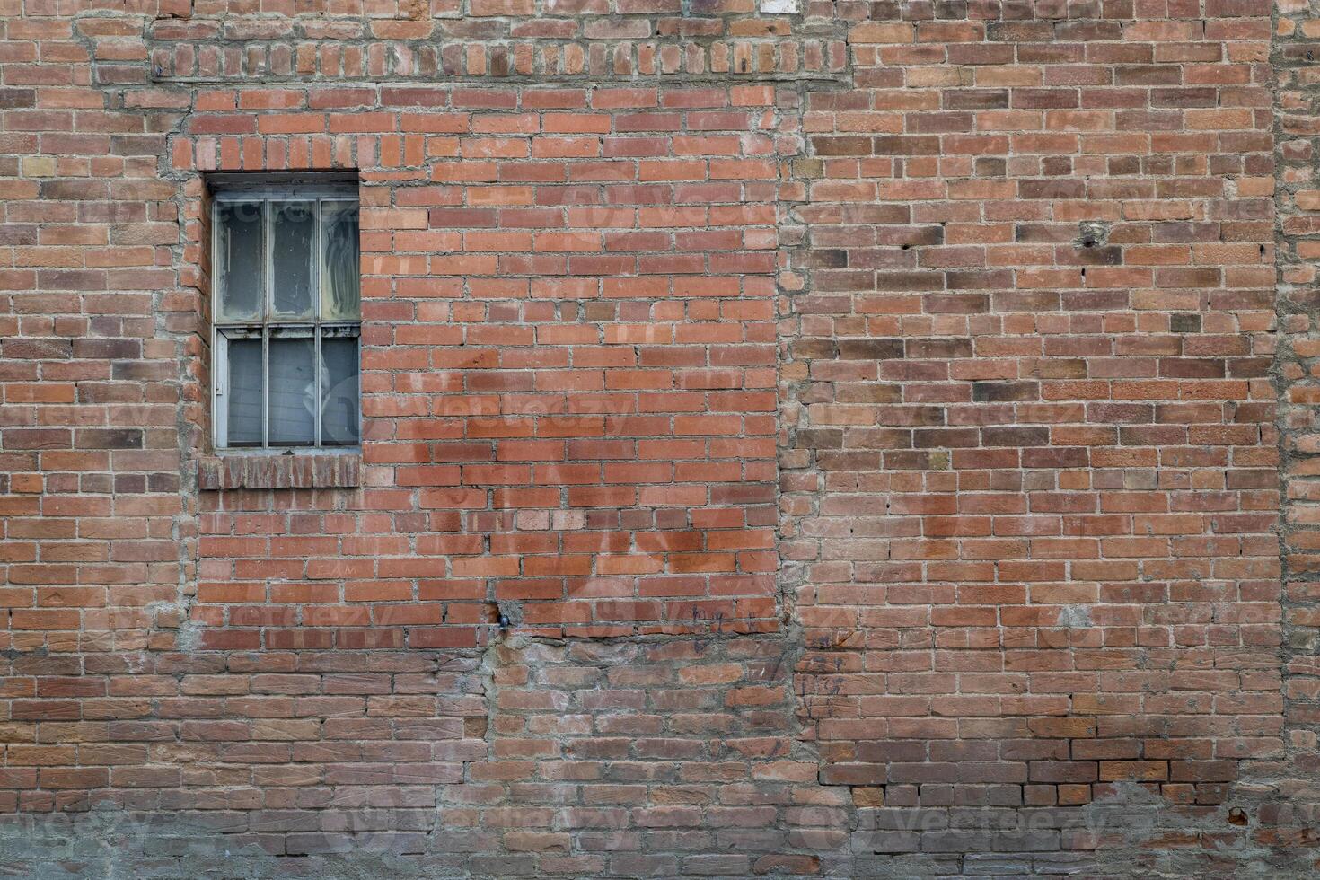 urban texture and background - grunge brick wall with a small, neglected window photo