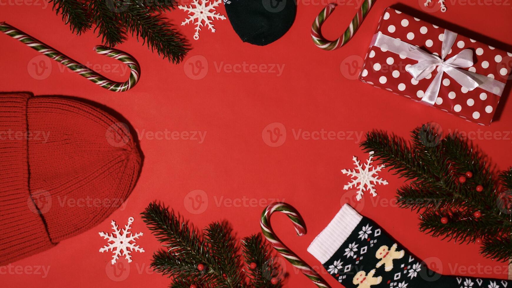 festivo Navidad marco en rojo antecedentes en nuevo año 2024 con rama, regalo, sombrero, caramelo caramelo, copos de nieve, medias. parte superior vista, de cerca, plano, Copiar espacio, composición foto