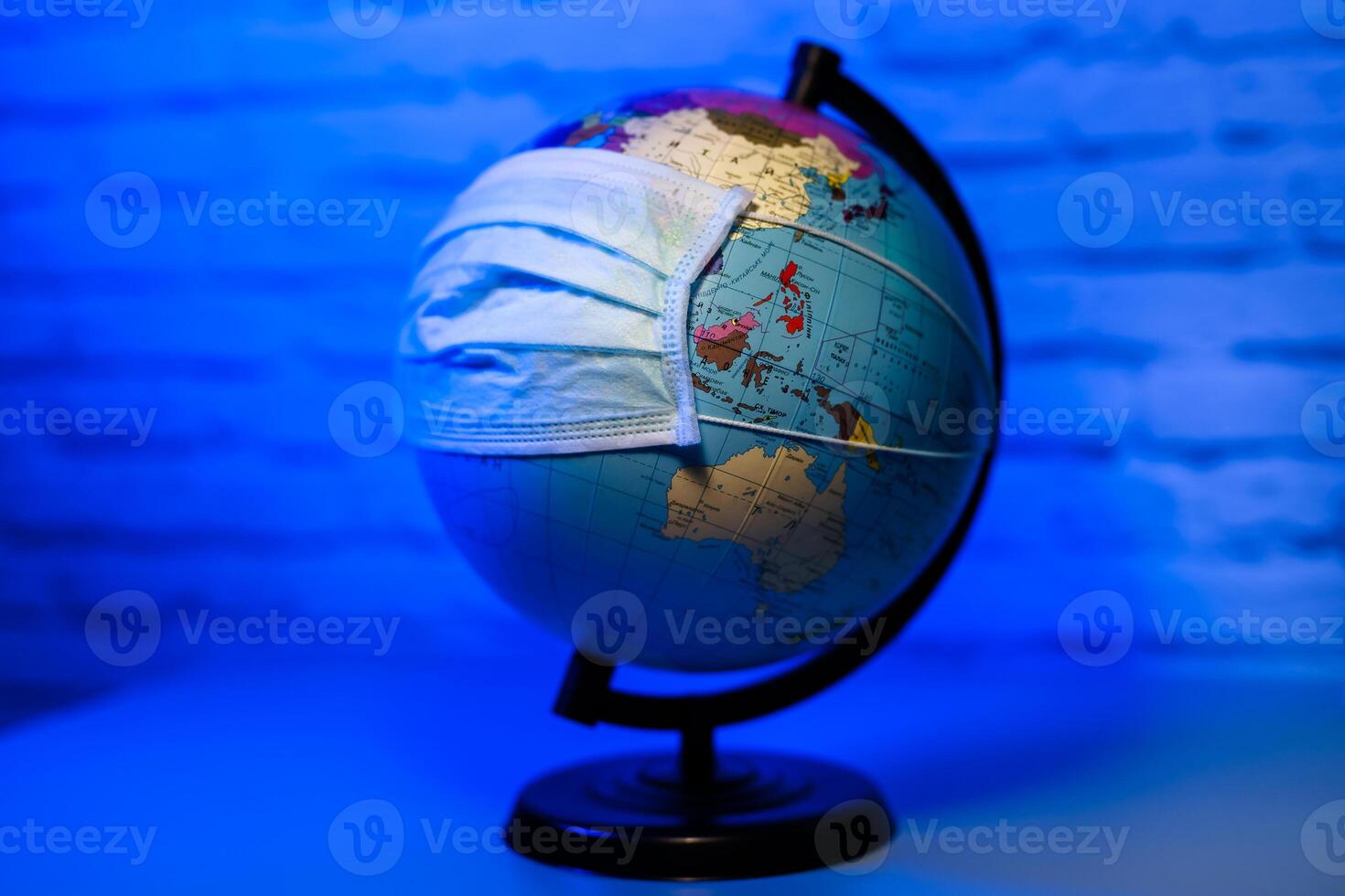 Medical mask on globe against a virus. Save the planet. Stop pandemic. photo