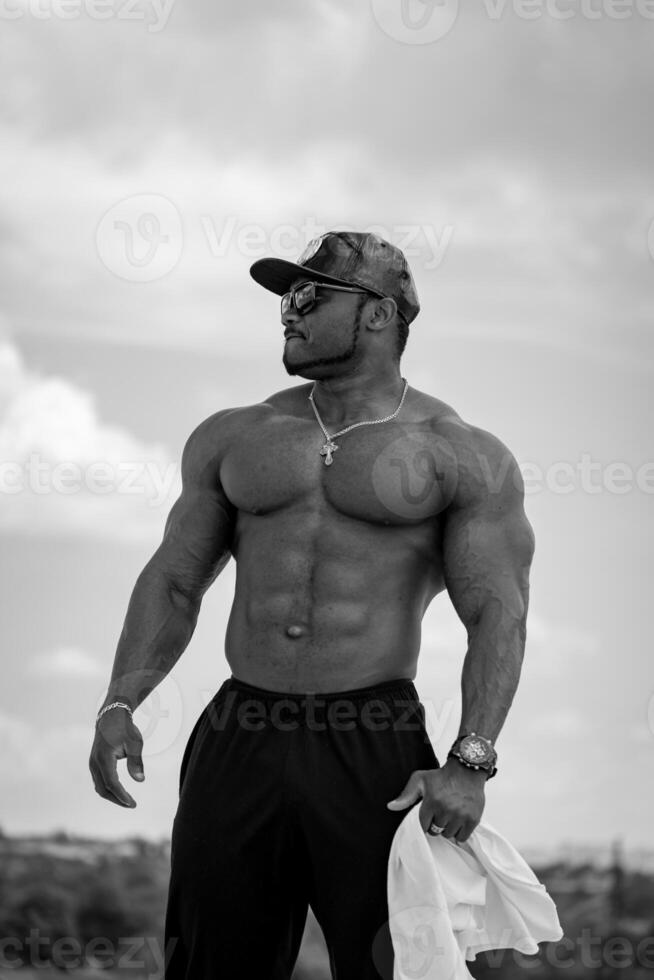 Shirtless muscular bodybuilder outdoor posing. Man with athletic muscles. photo