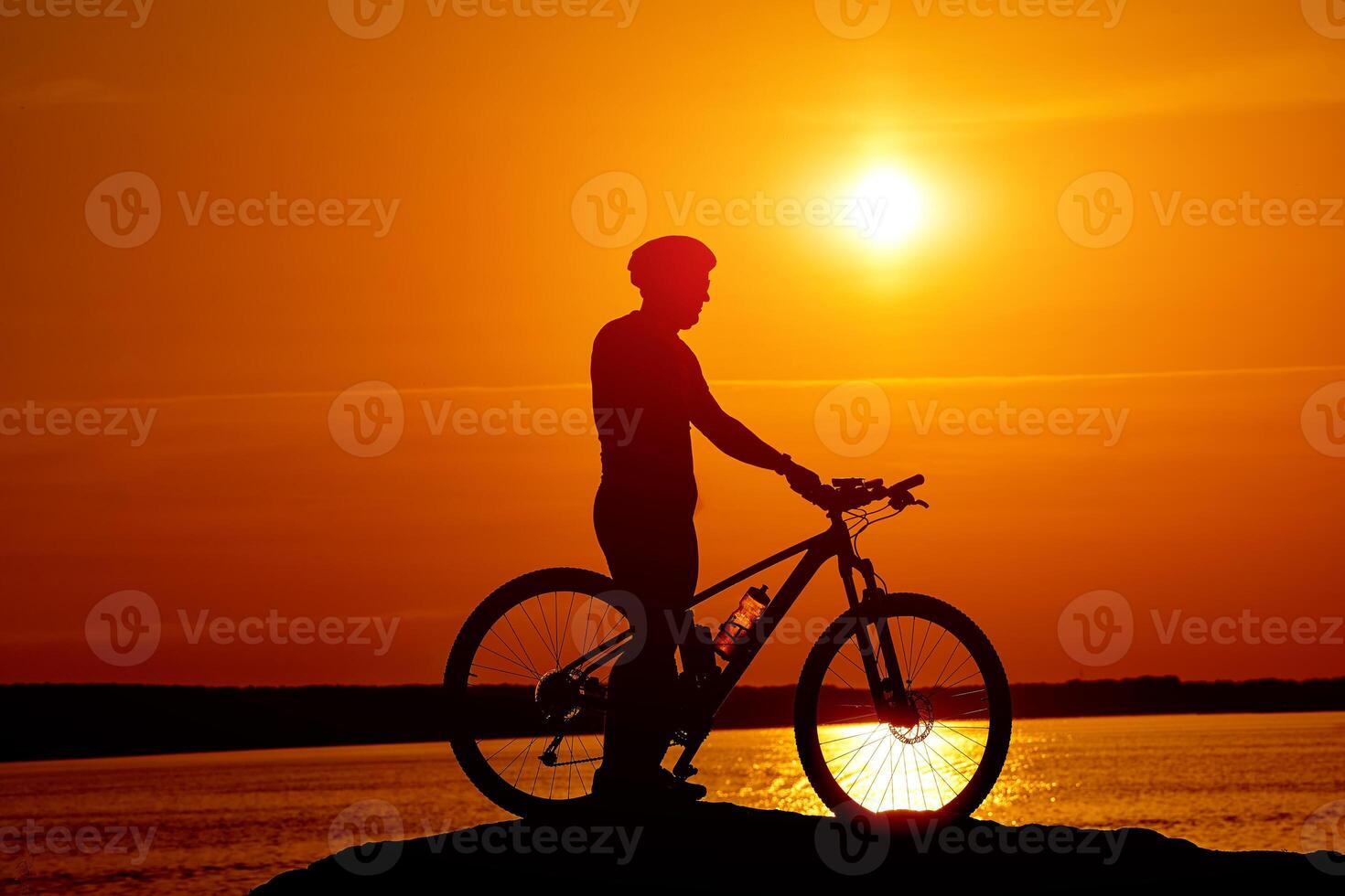 Silhouette of race cyclist. Shadow behind the sun of cycling man. photo