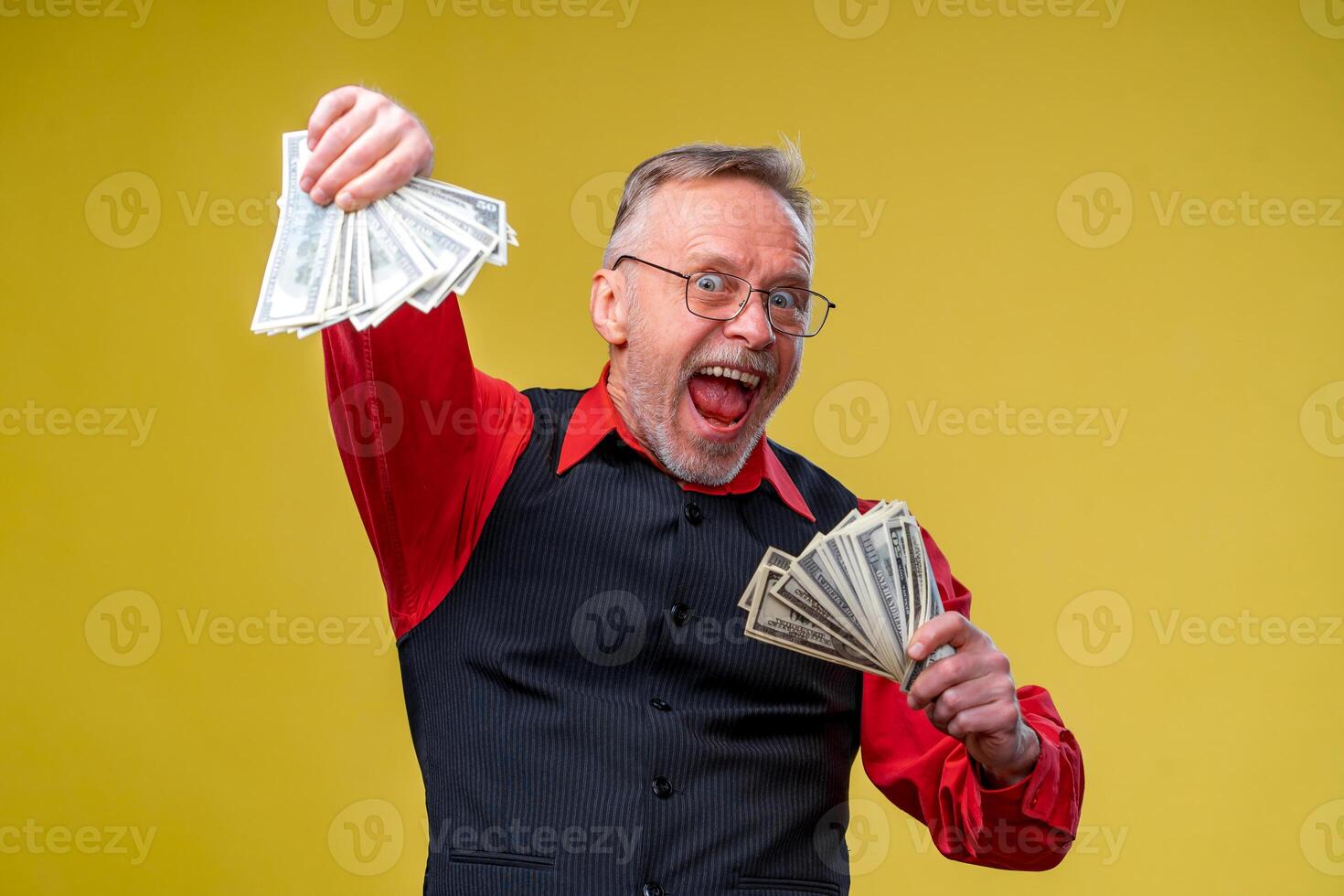 hombre participación un montón de dólar cuentas en manos, aislado en amarillo antecedentes. contento hombre disfrutando dinero. manos con dinero. Rico con éxito. positivo emoción facial expresión sentimientos. foto