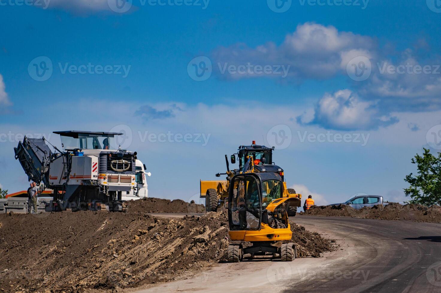 An excavator in a road construction site. Yellow special technic, machinery. Road repair concept. photo