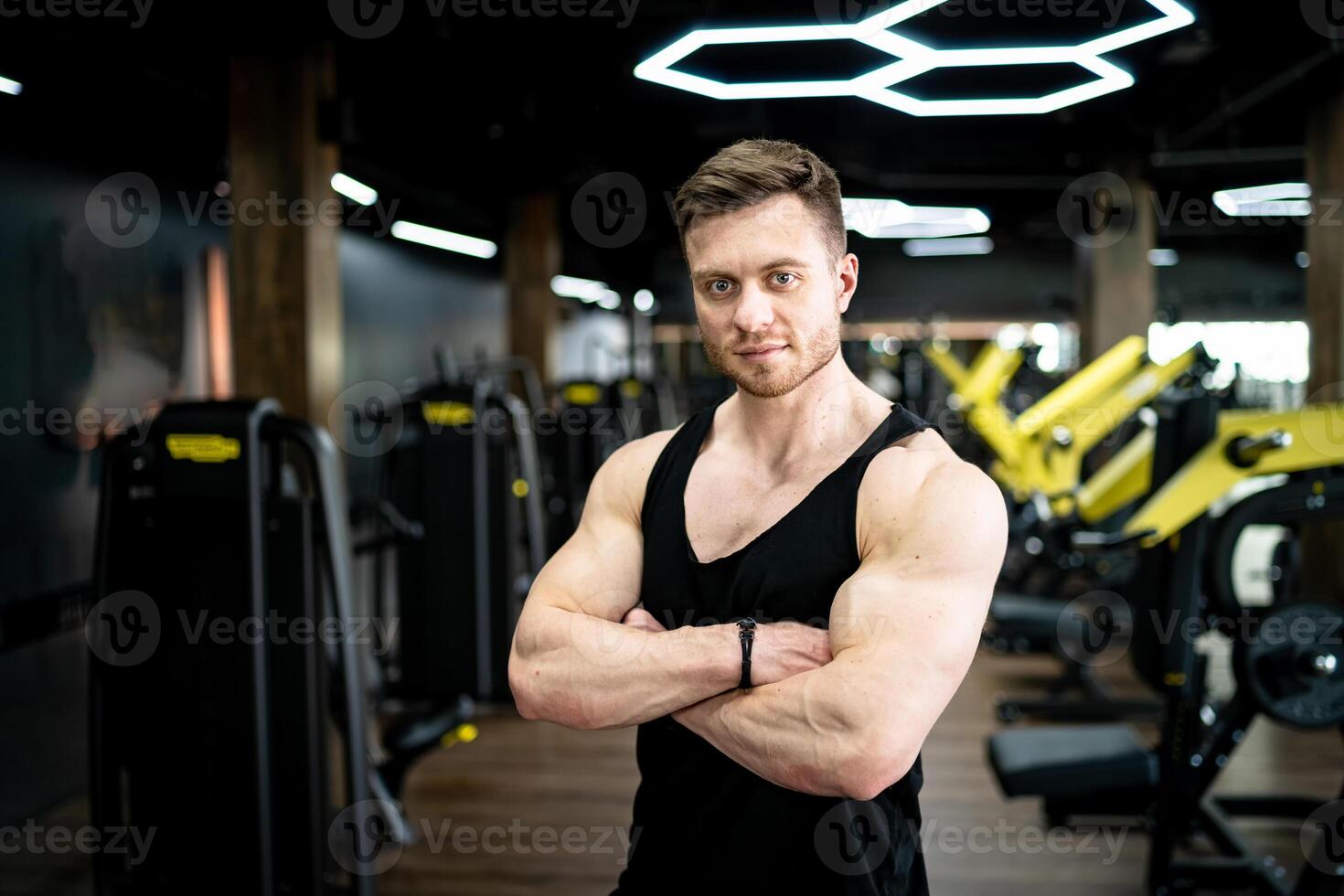 Athletic young male model with strong hands. Handsome strong man posing at the gym. photo