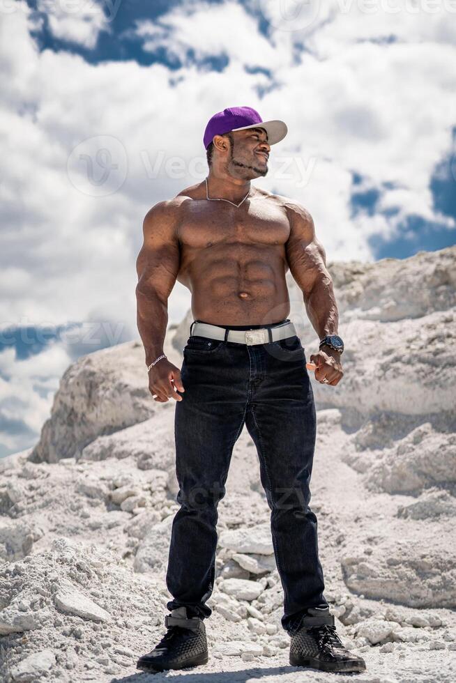 fuerte sano sin camisa hombre. muscular joven carrocero con desnudo torso en pie en paisajes foto