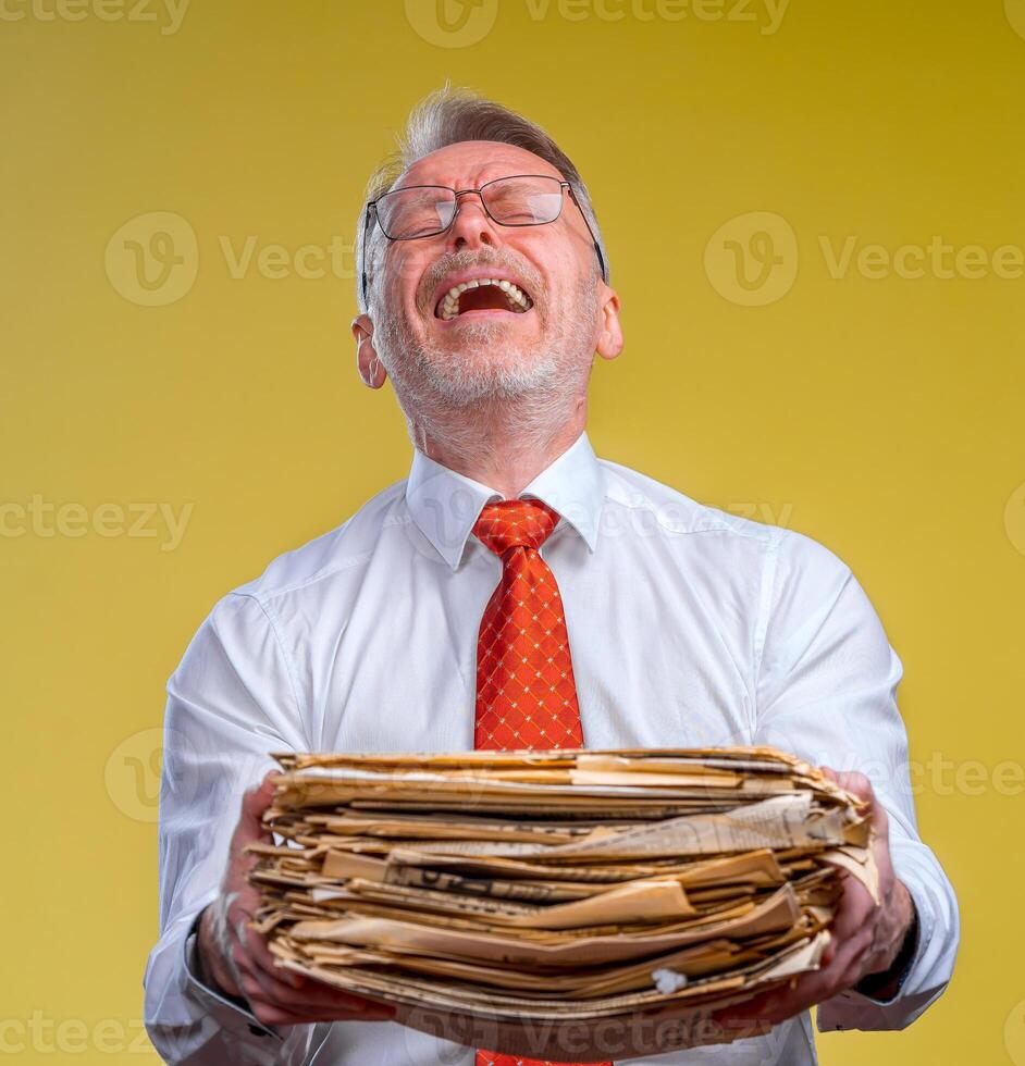 Files in hands of a surprised businessman or manager isolated on yellow background. photo