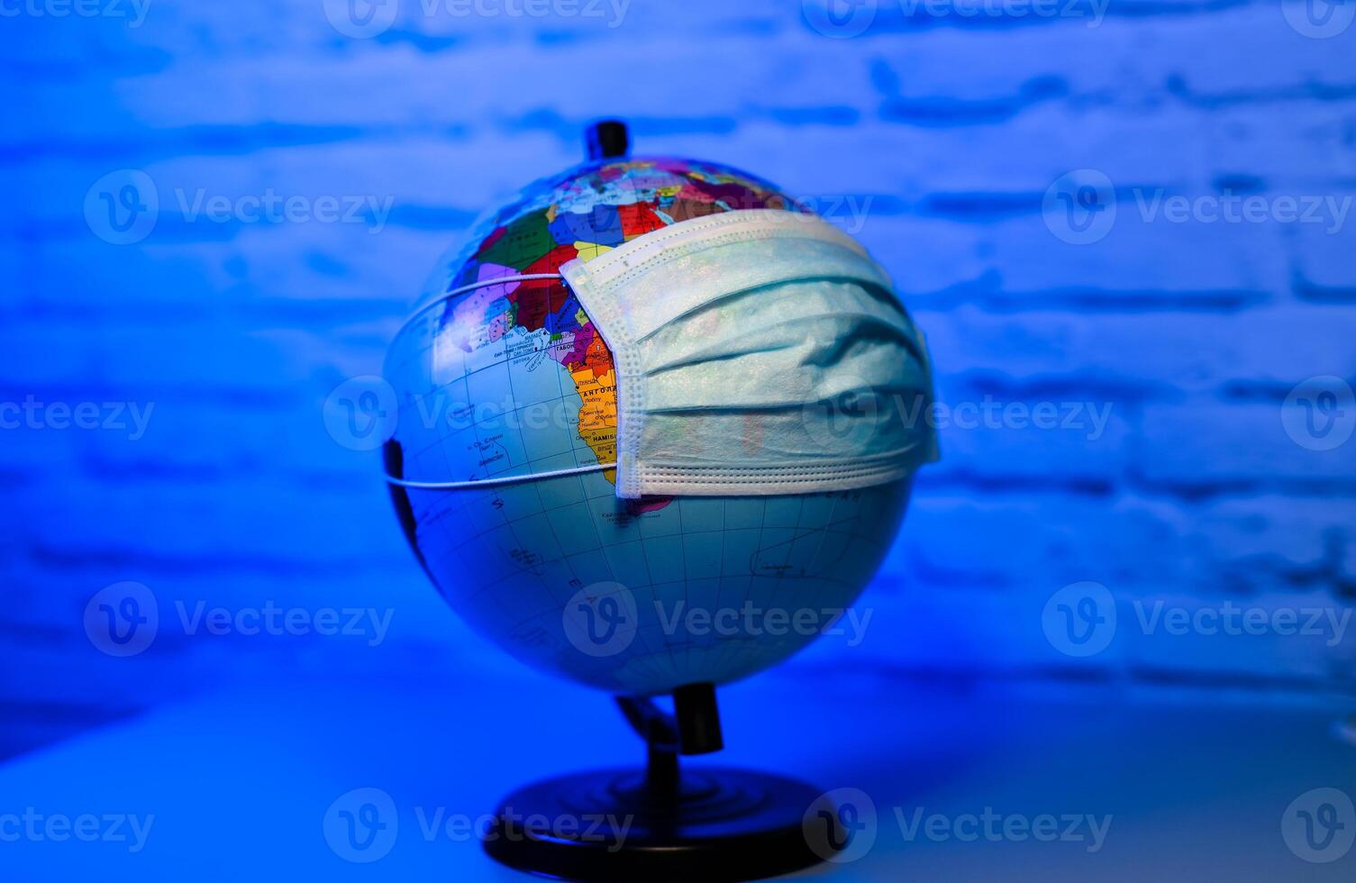 Medical mask on globe against a virus. Save the planet. Stop pandemic. photo