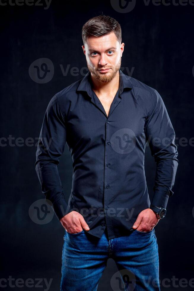 Portrait of handsome man in a studio on a dark background. Elegant young man. Sexy young guy with modern hairstyle. photo