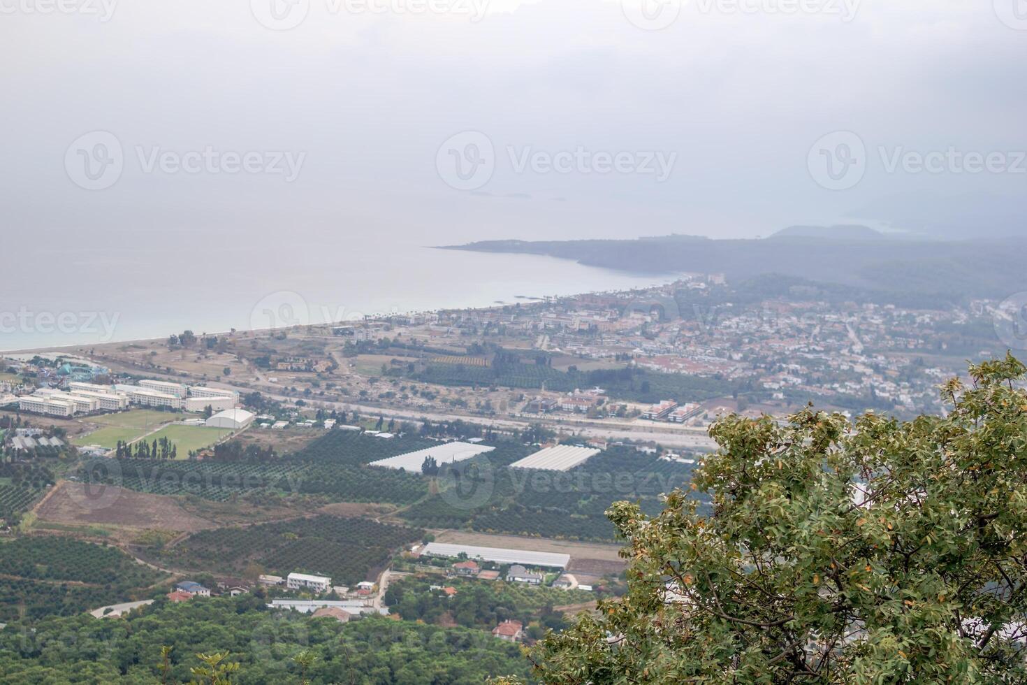 Panoramic cityscape and sea view from the mountain covered with trees against the sky. Kemer, Turkey photo